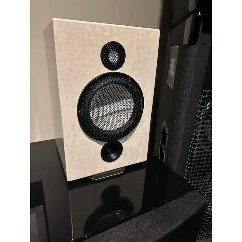 A modern speaker with a beige fabric cover on a black surface.