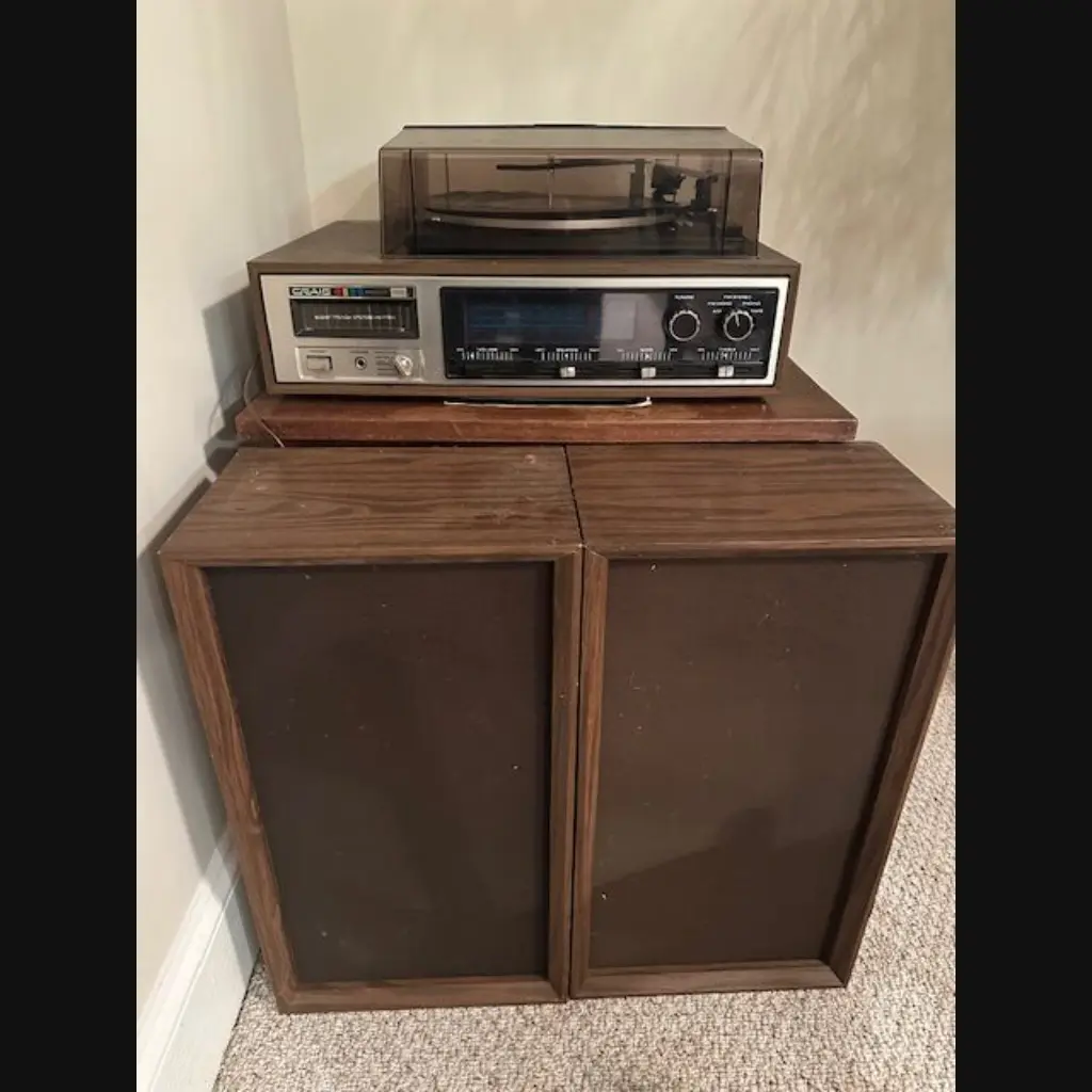 Vintage audio system with turntable and speakers in wooden casing.