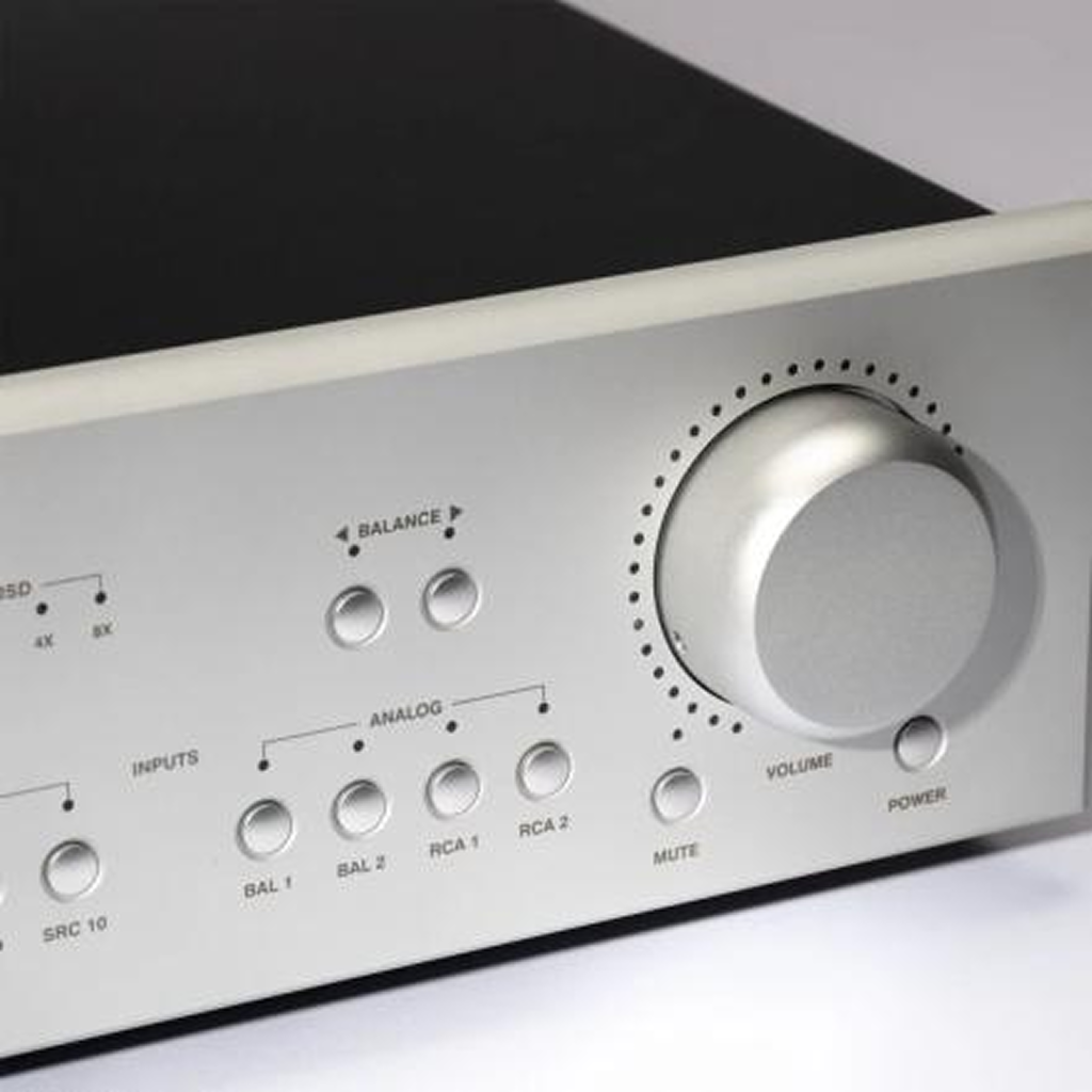 Close-up of a silver audio amplifier with control knobs and buttons.