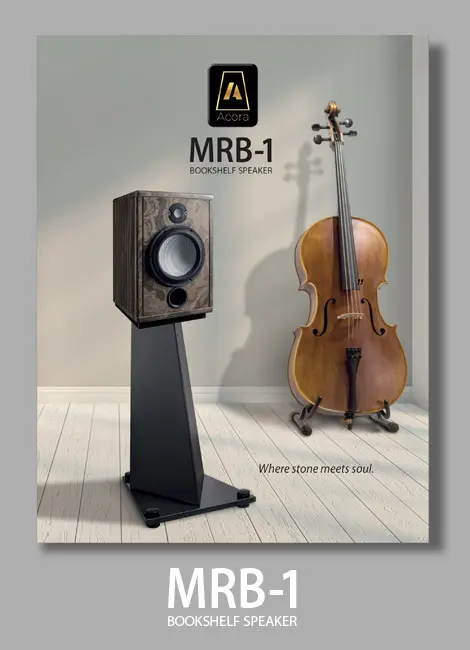 High-end MRB-1 speaker on a stand beside a cello in a stylish room.