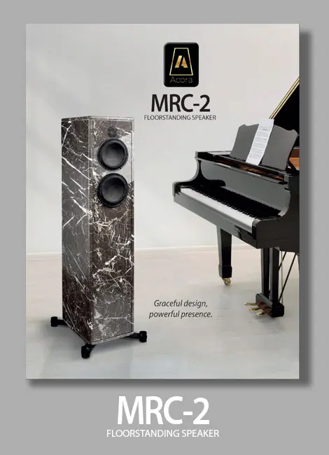 Elegant marble speaker next to a grand piano in a stylish setting.