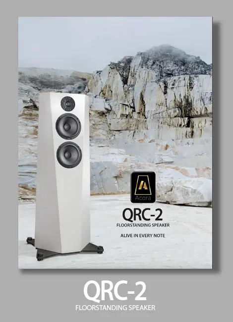 White QRC-2 audio speakers with rocky background.