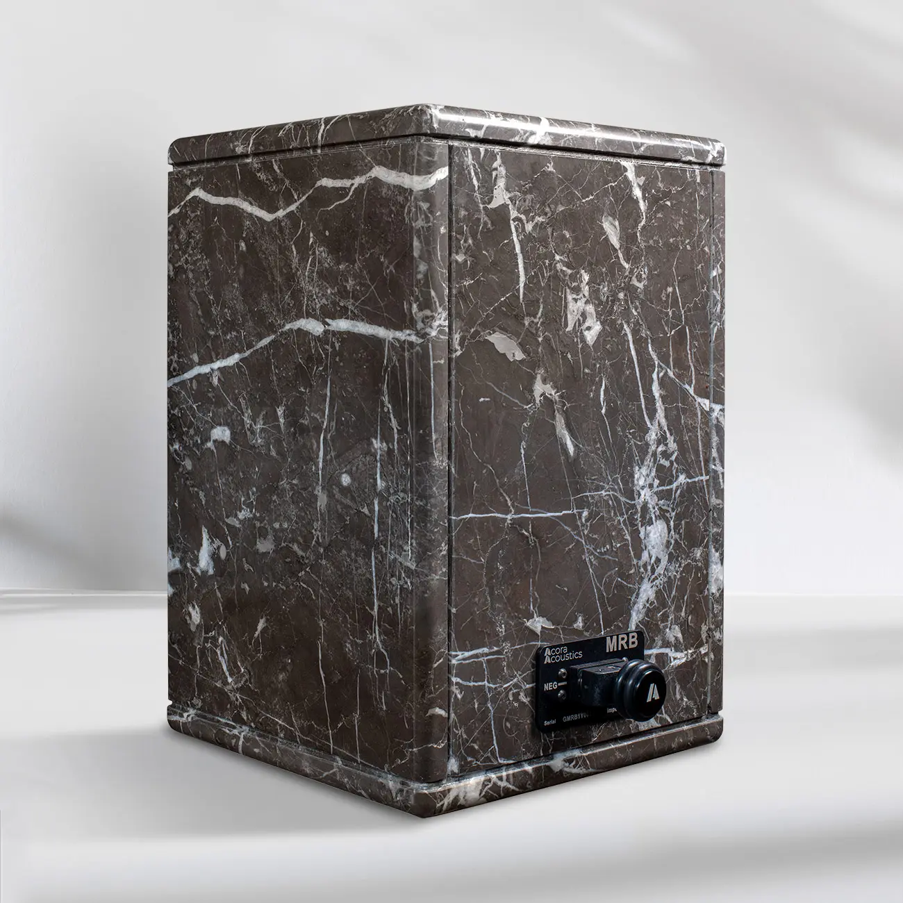Modern black marble speaker with a sleek design and control knob.
