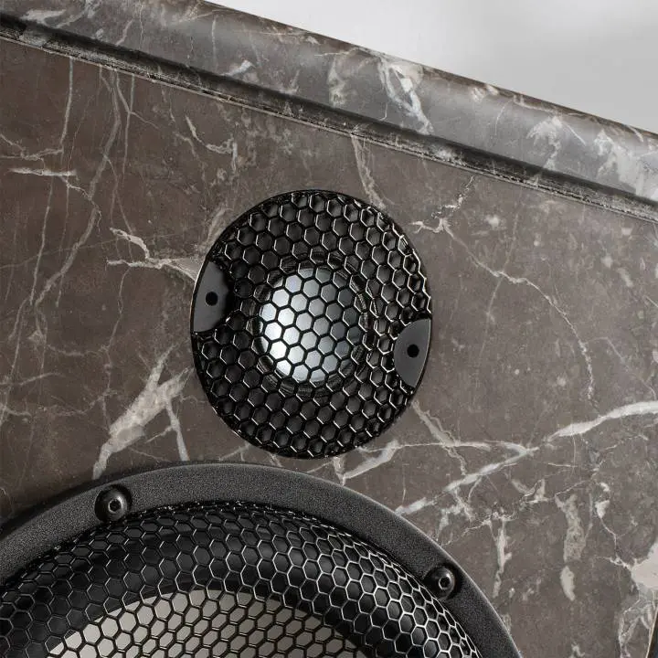 Close-up of a speaker on a marble surface.
