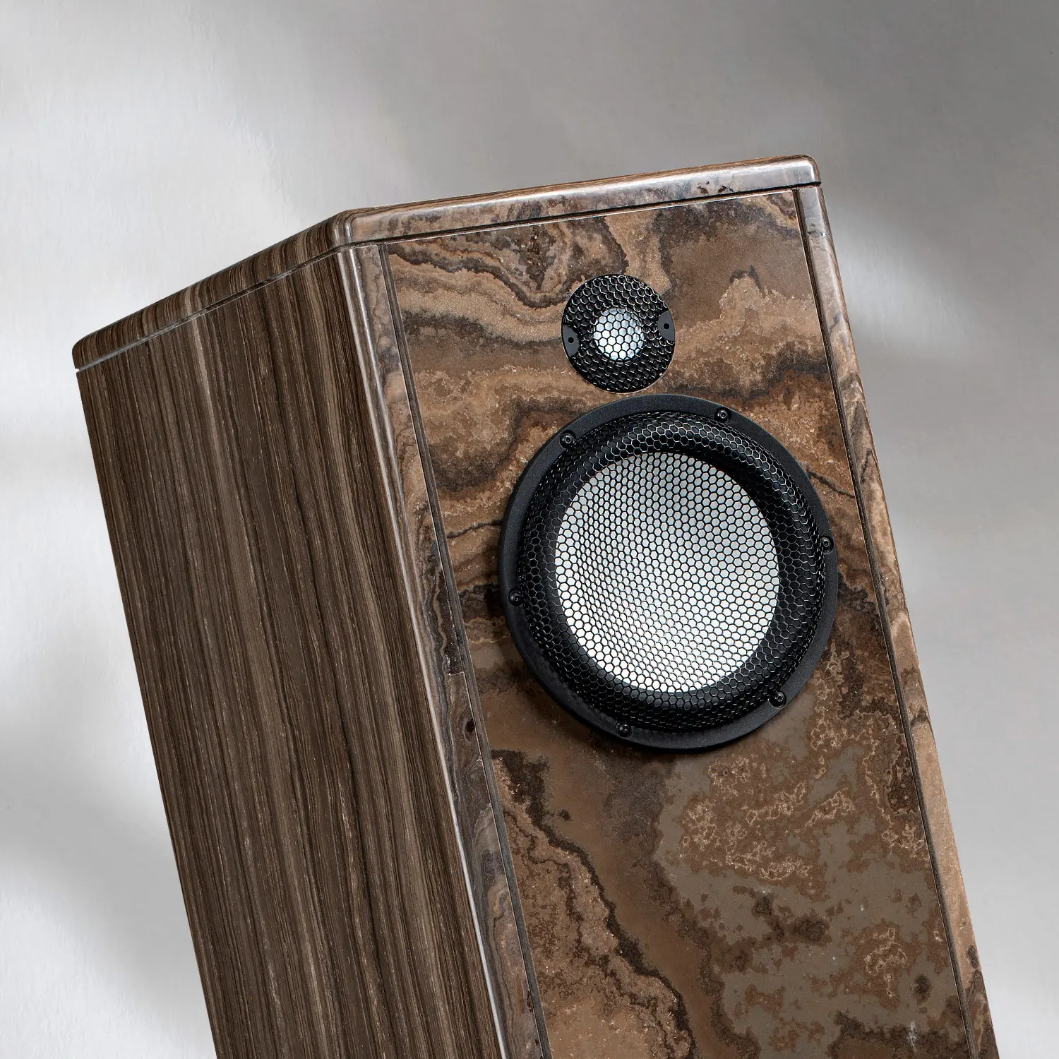 Close-up of a wooden speaker with a round tweeter and woofer.