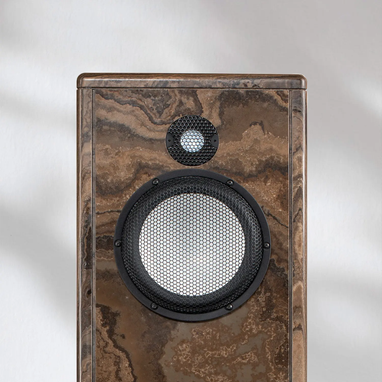 Close-up of a stylish wooden speaker with a circular grille and tweeter.