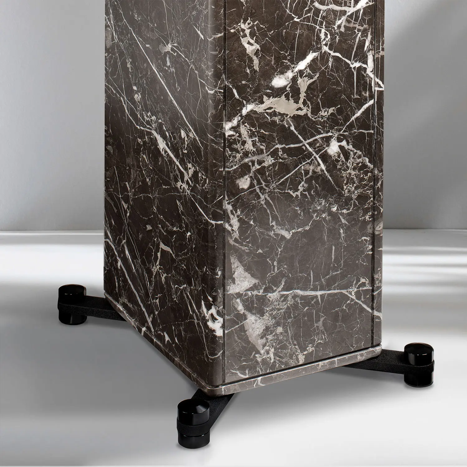 Close-up of a marble pedestal with caster wheels on a smooth floor.