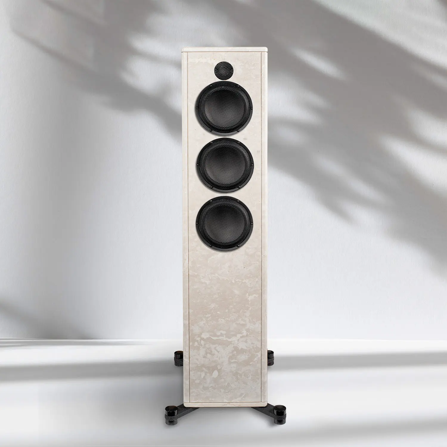 Tall beige speaker with three black drivers on a white surface.
