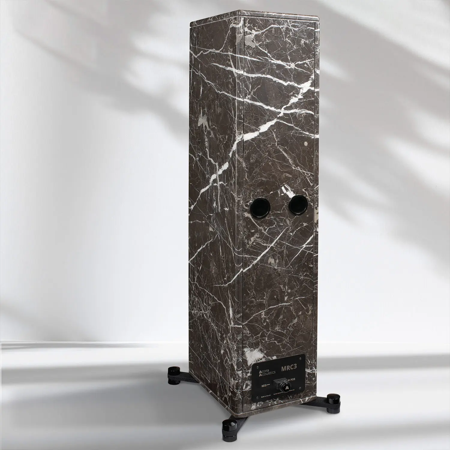 A tall, rectangular black marble sculpture with white veins and two circular holes.