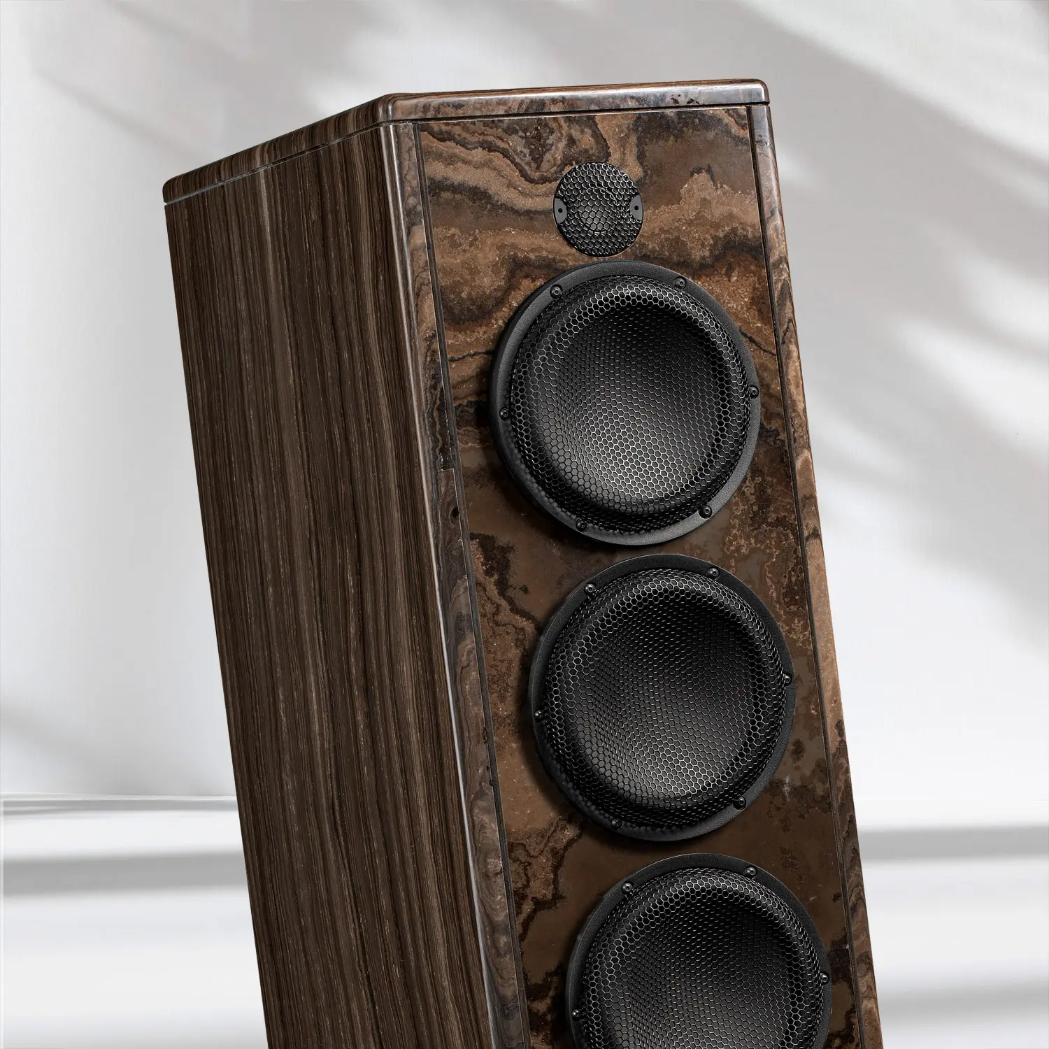 Tall wooden speaker with three circular drivers.