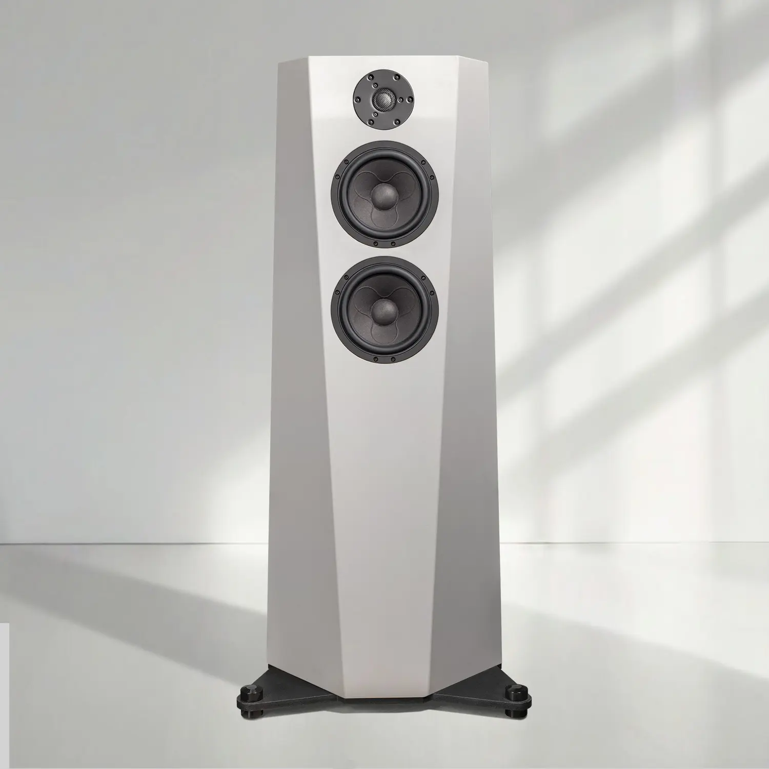 Modern white floor-standing speaker with three drivers and black base.