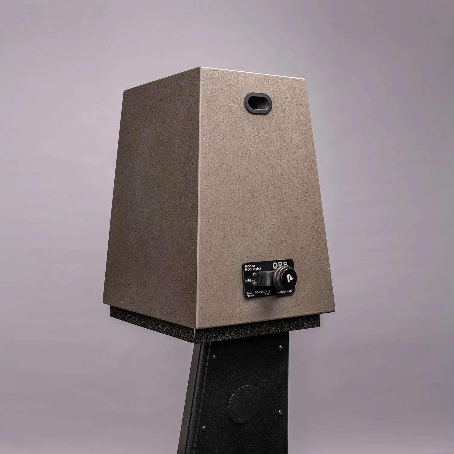 Modern speaker with retro design on a black stand.