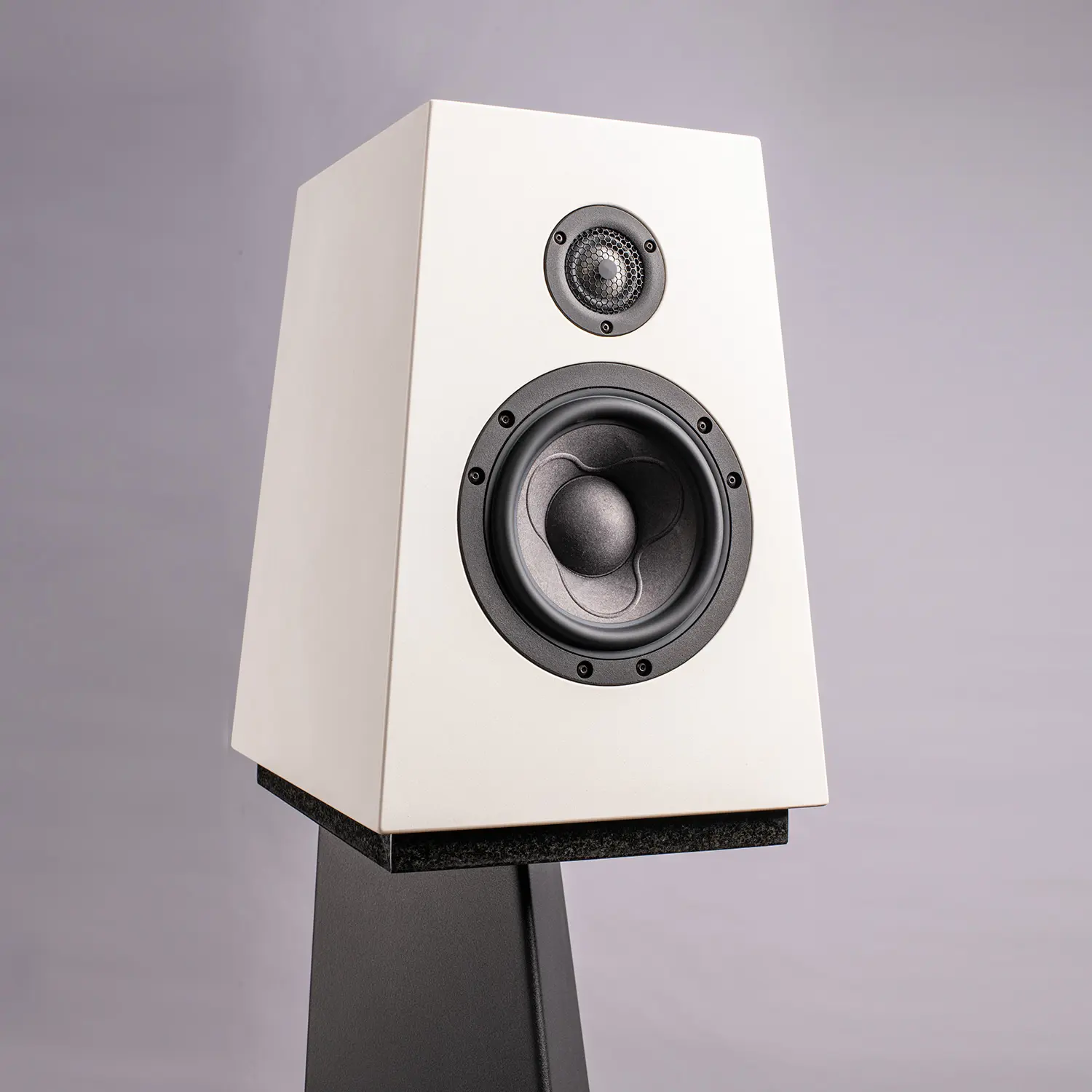 Modern white speaker on a black stand against a gray background.