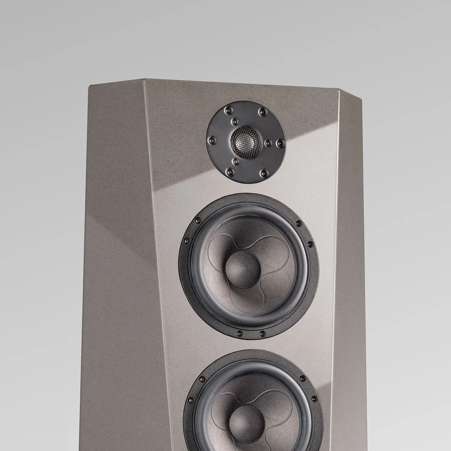Modern gray floor-standing speaker with three drivers.