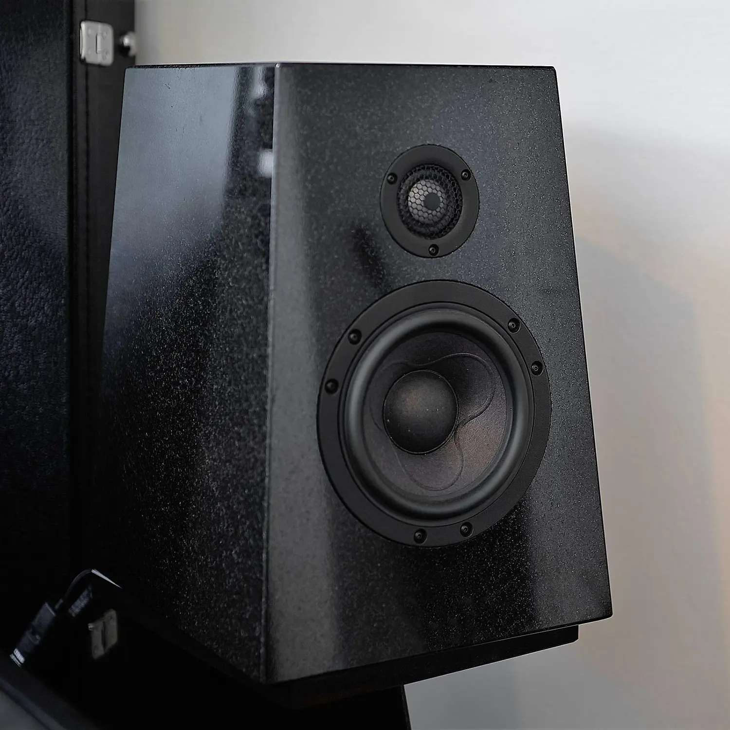 Black bookshelf speaker with two drivers on a stand.
