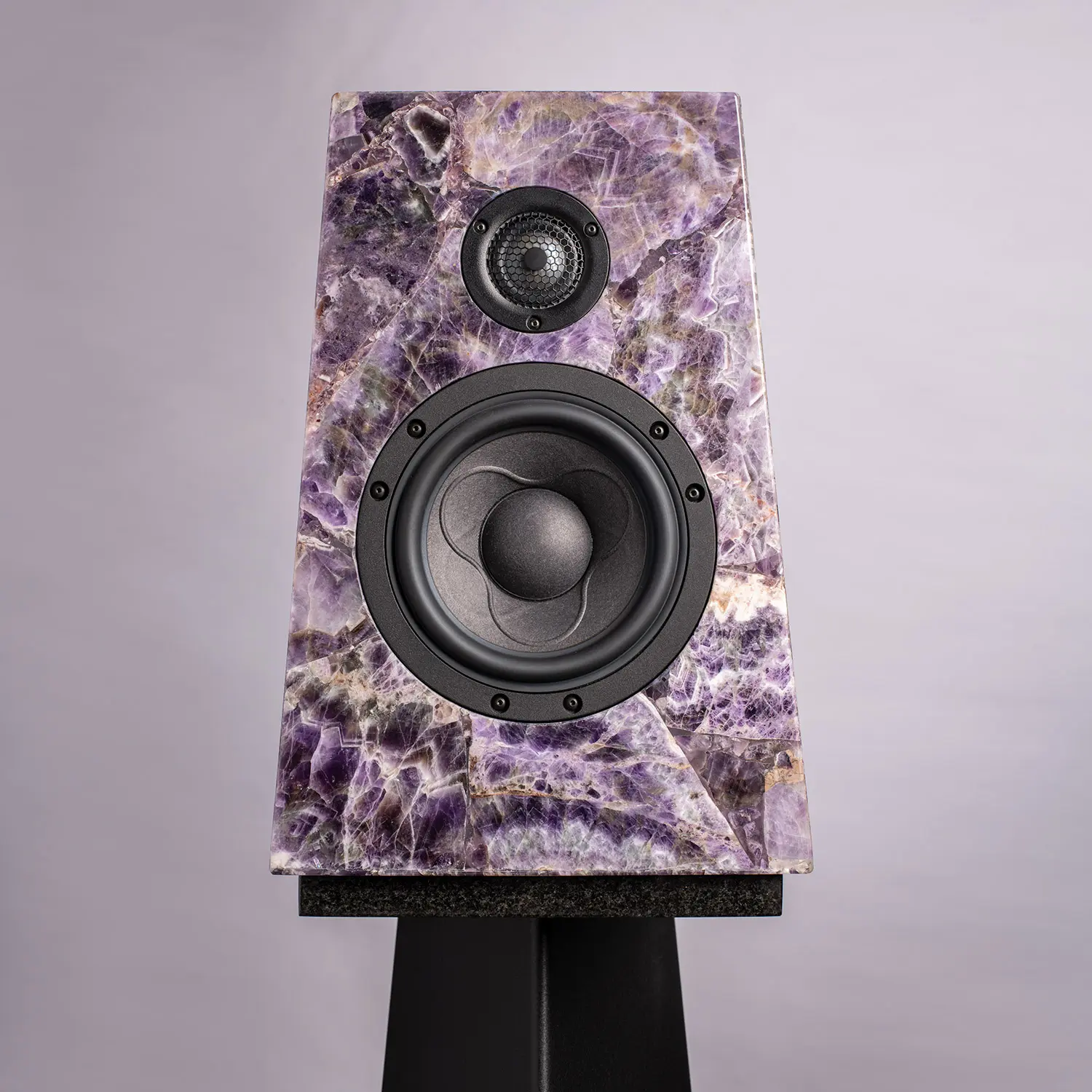Speaker with amethyst crystal design on a stand.