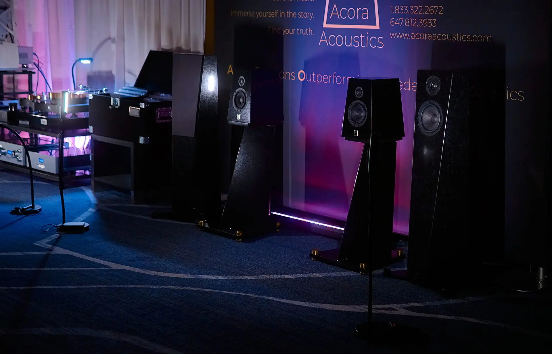 High-end speakers displayed in a dimly lit showroom.