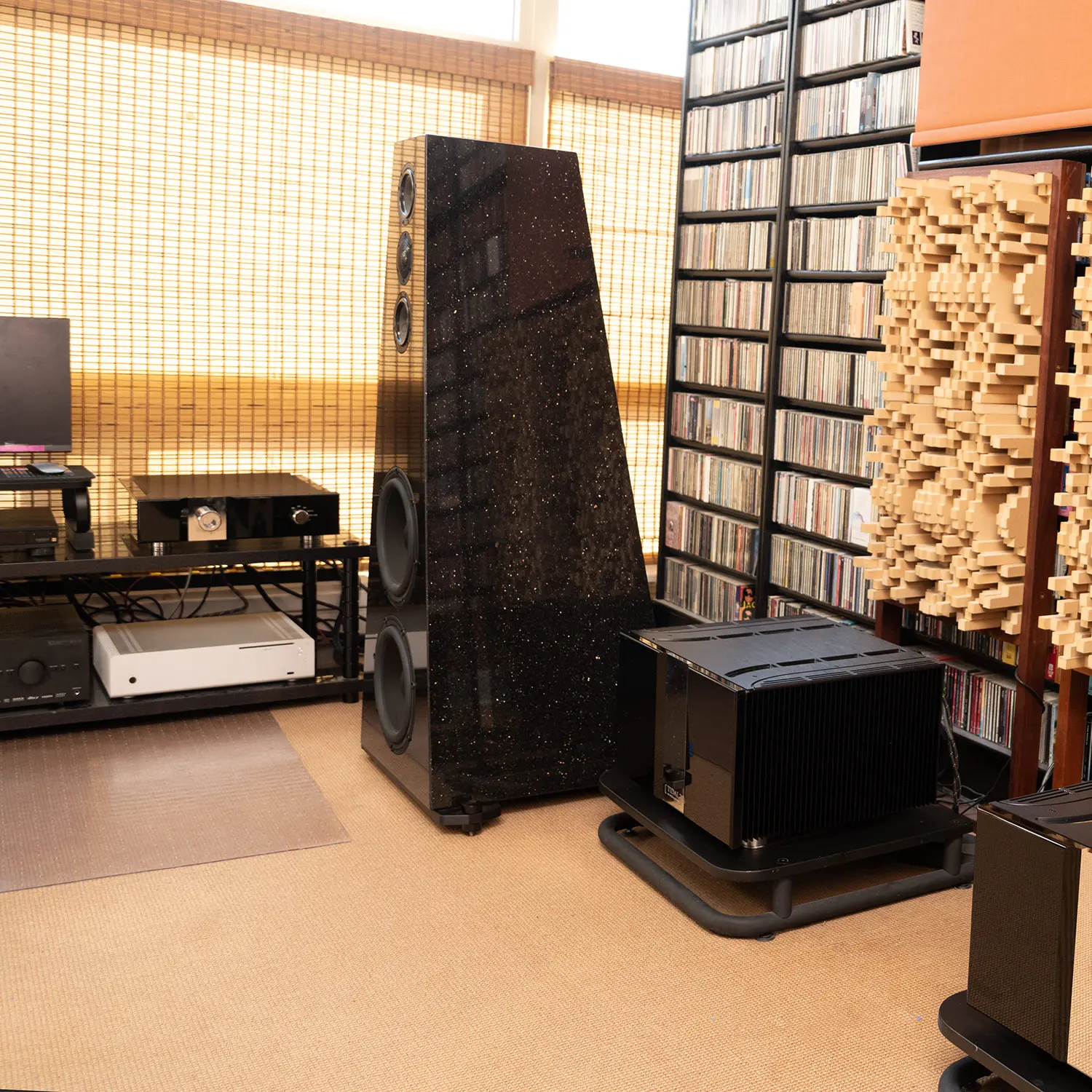 High-end audio setup with speakers and acoustic panels in a cozy room.