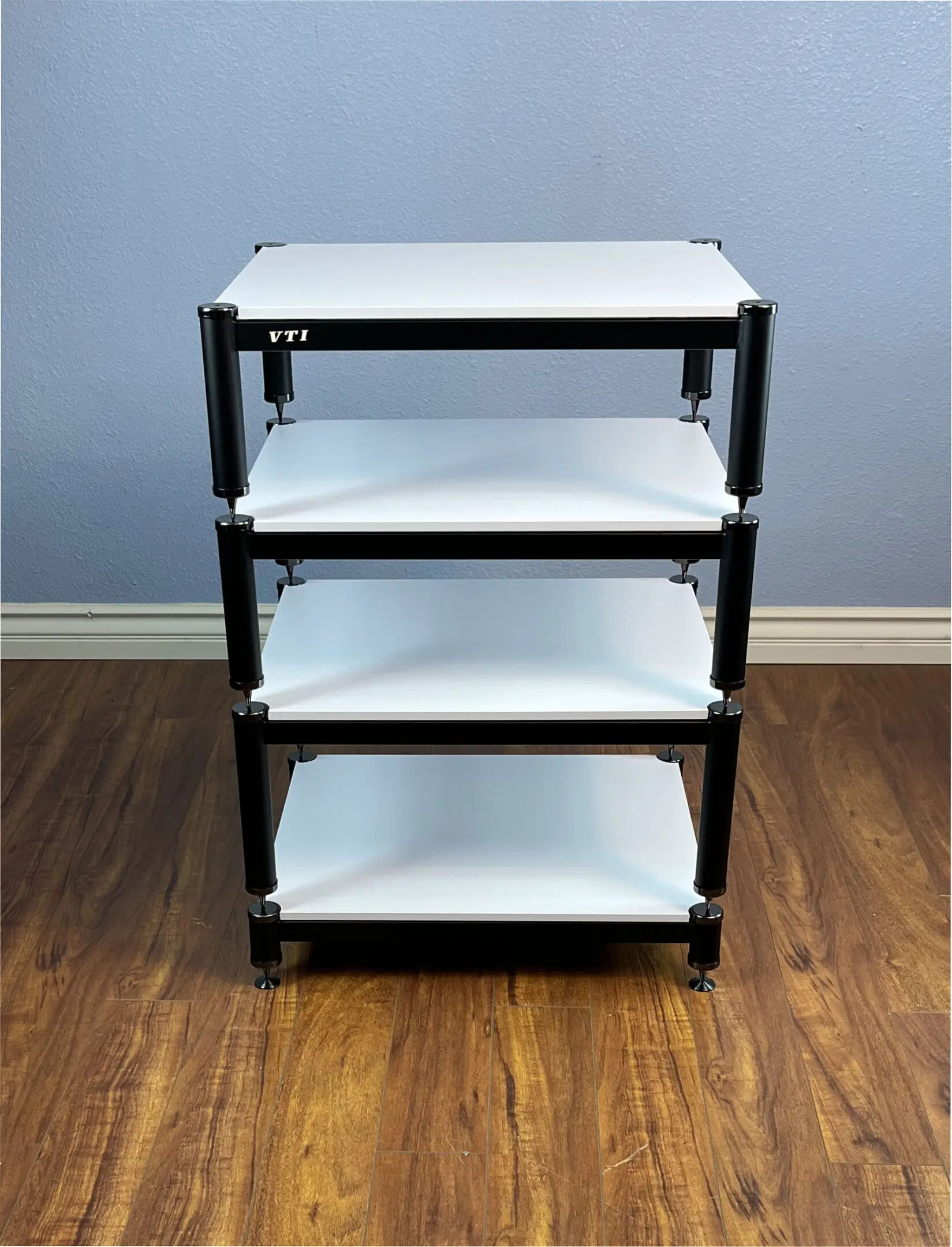 A four-tier black metal and white shelf unit on wheels.