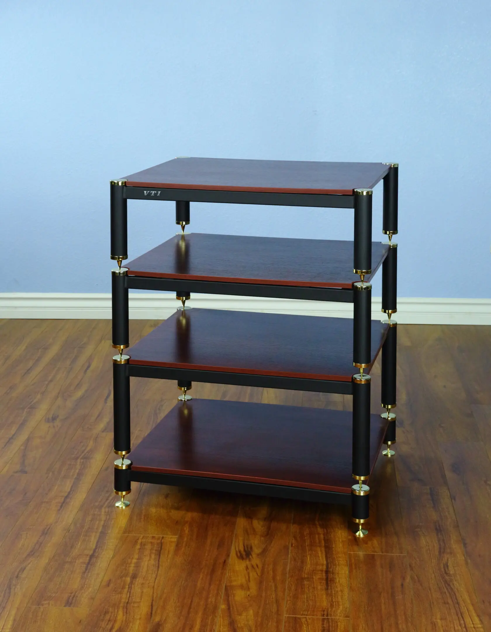 A four-tier wooden shelving unit with metal supports on a hardwood floor.