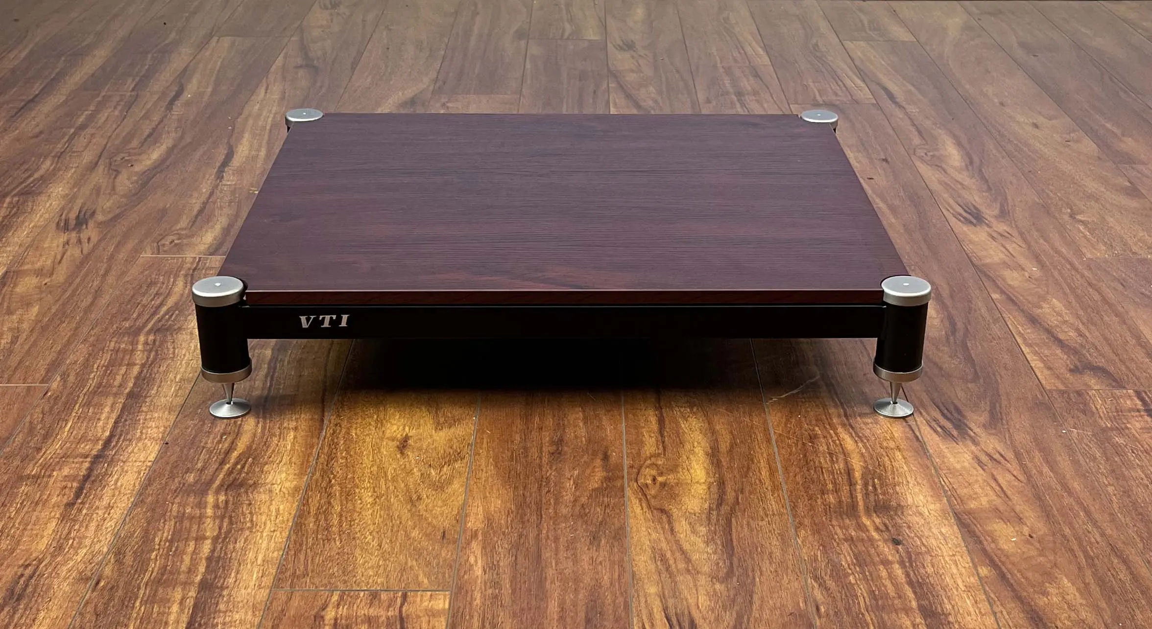 Wooden footrest with adjustable height on a wooden floor.