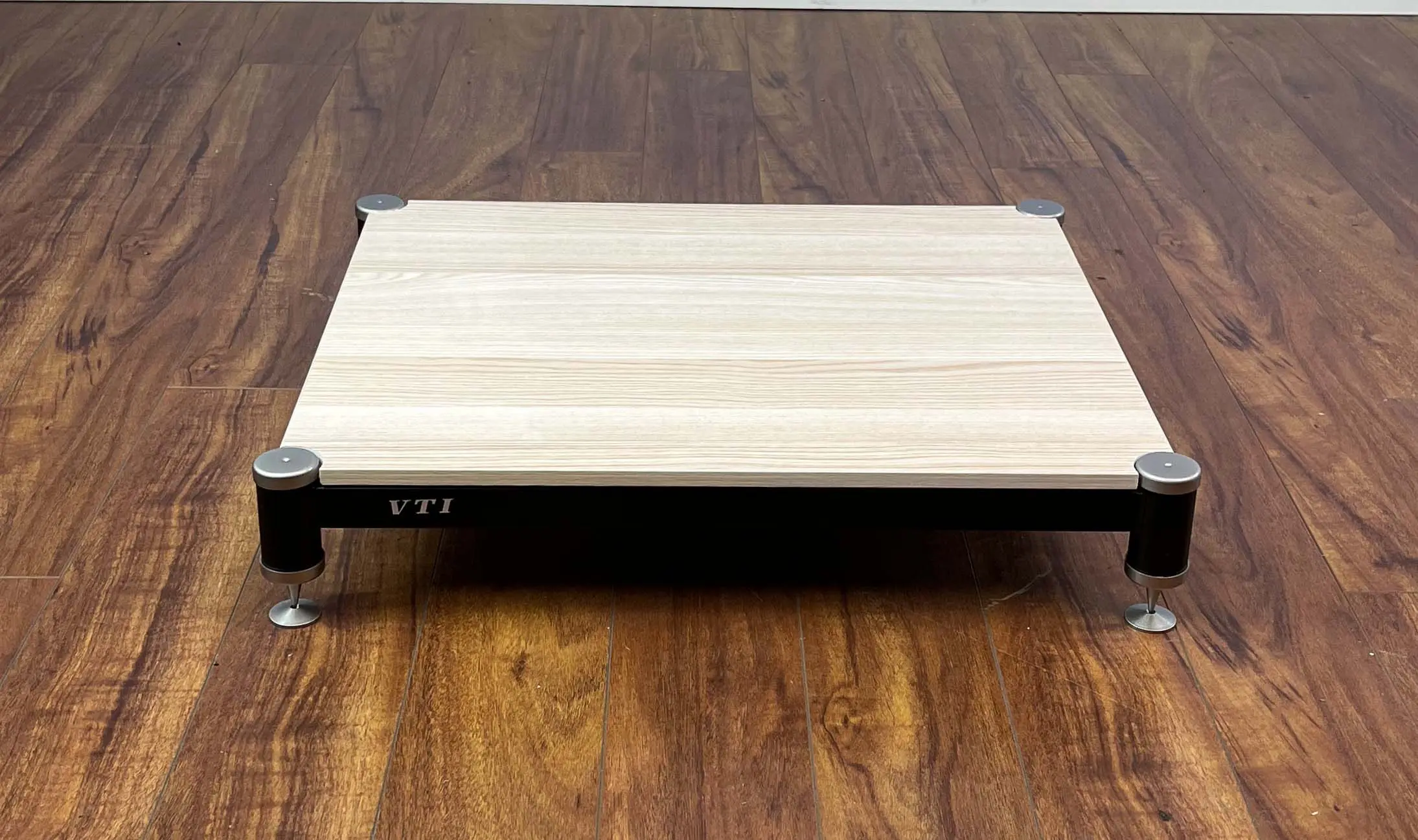 Wooden laptop stand on a wooden floor.