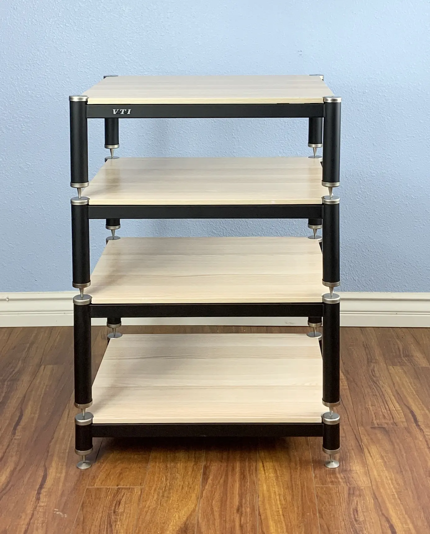 A modern wooden shelving unit with four tiers and black frame.