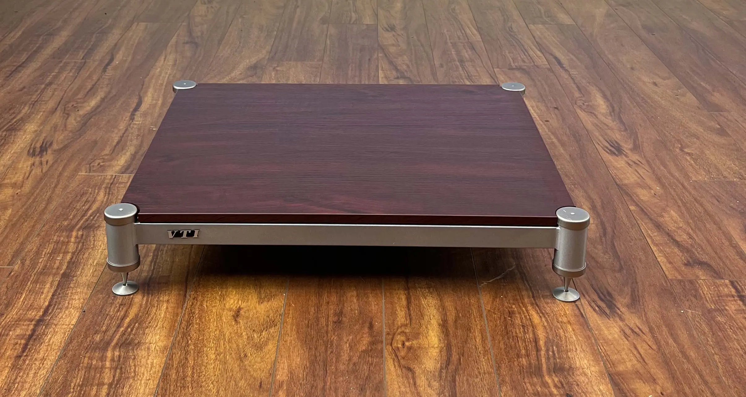 Wooden platform with metal legs on a wooden floor.