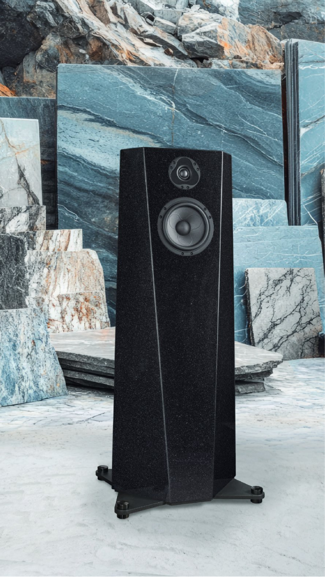 A sleek black floor-standing speaker against a marble backdrop.