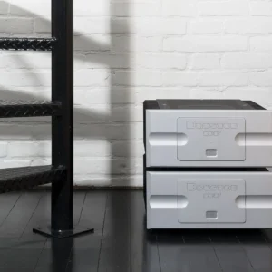 Two gray storage boxes stacked near a black metal staircase on a dark floor.