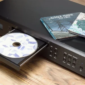 A CD player with an open tray and CDs on top.