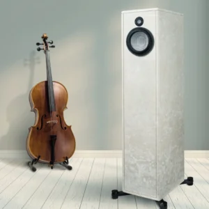 A cello and a modern speaker stand side by side on a wooden floor.