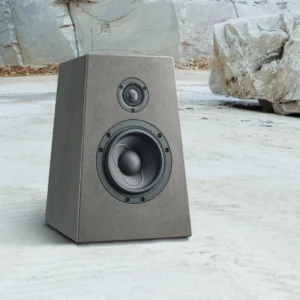 A gray speaker with two drivers on a concrete floor.