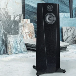 Tall black floor-standing speaker in a marble showroom.
